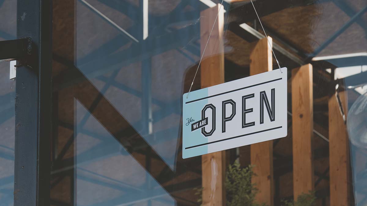 "Yes we are Open" sign in shop window